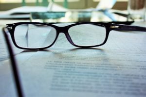Reading glasses resting on a contract