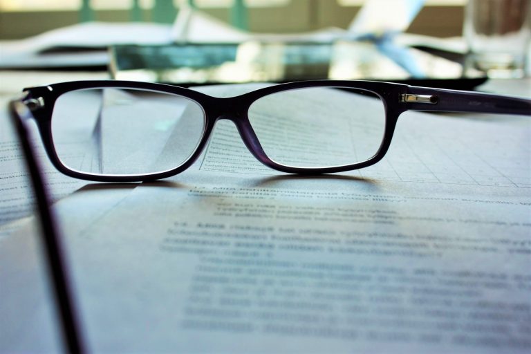 Reading glasses resting on a contract