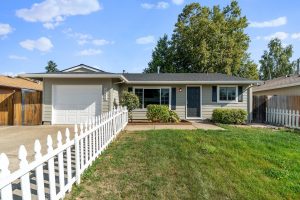 Image of a starter-home with a white picket fence